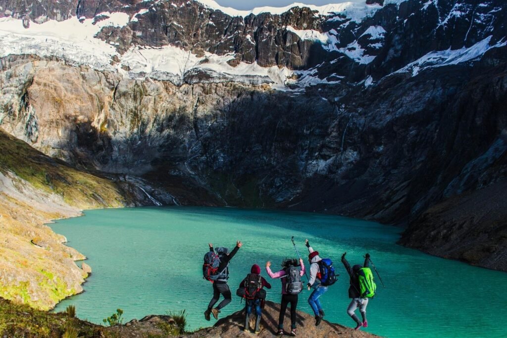 A group of people jump in the air for a picture beside a lake on Chimborazo, Ecuador