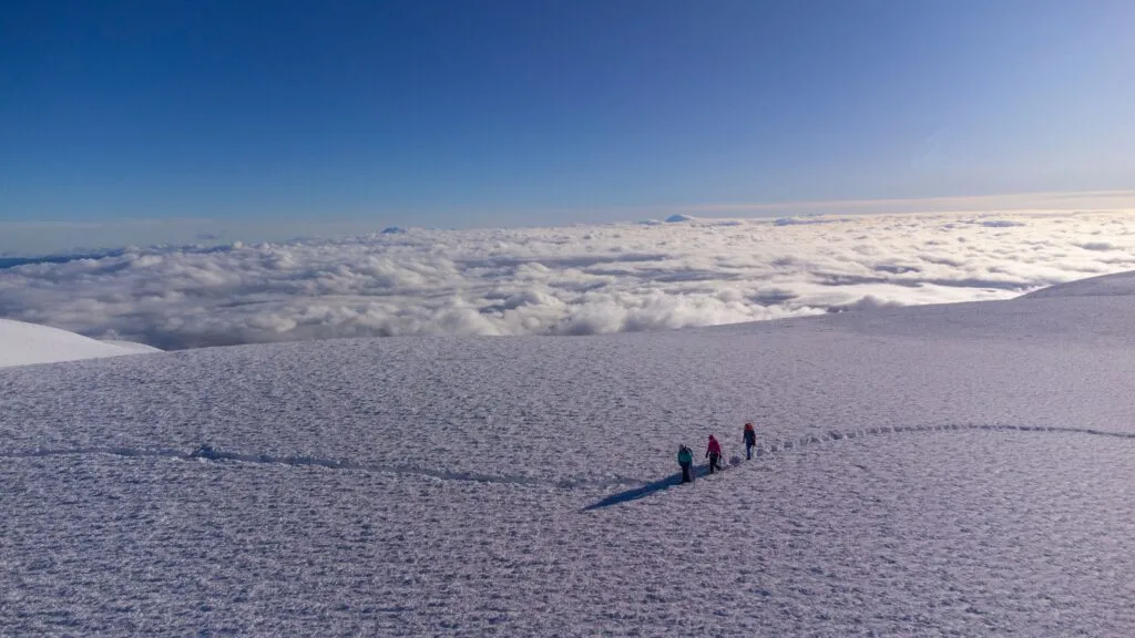 People hike along the snow on top of Chimborazo, Ecuador
