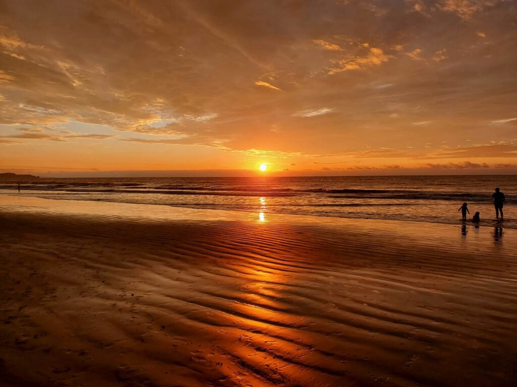 Sunset is refelected in the ocean and beach at Tonsupa. Wheely Tyred best travel insurance for coastal Ecuador