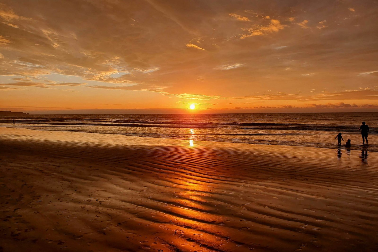Sunset is refelected in the ocean and beach at Tonsupa, Ecuador