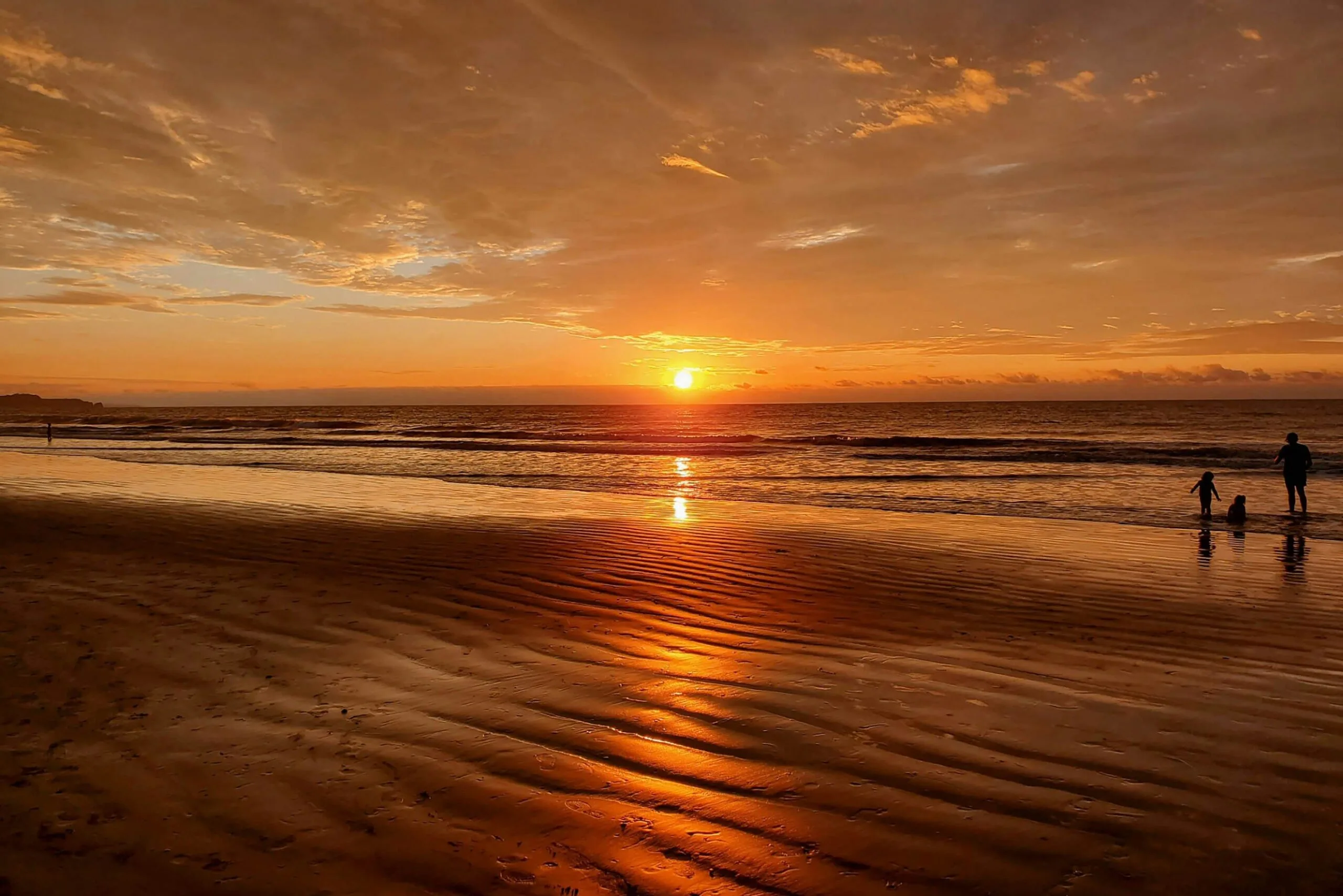 Sunset is refelected in the ocean and beach at Tonsupa, Ecuador